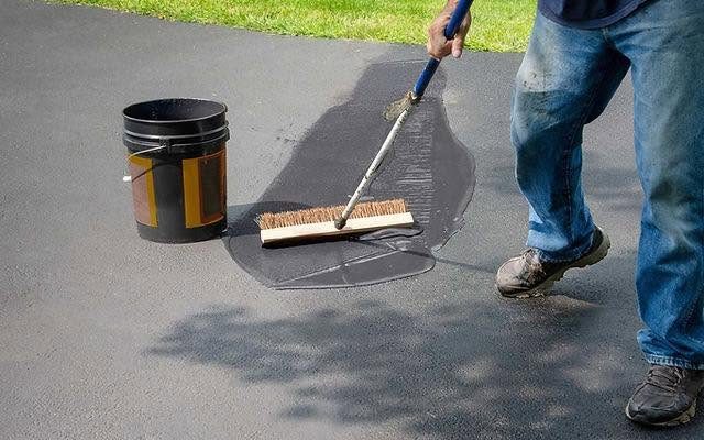 Applying protective asphalt seal coat to a driveway