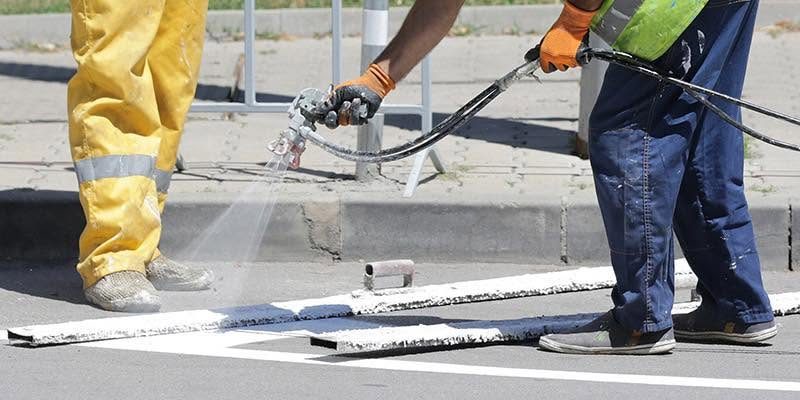 Proline crew spray-applying fresh pavement line striping