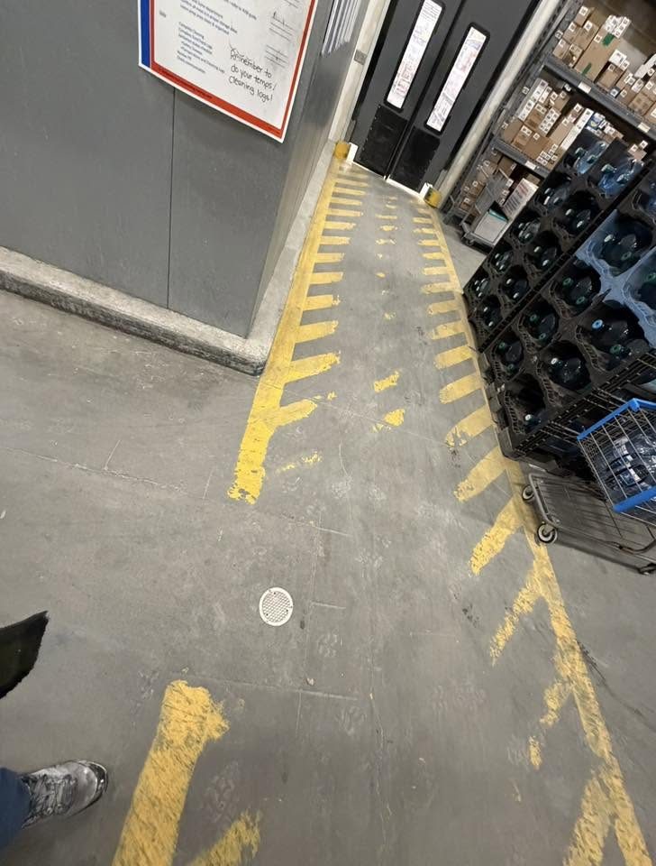 Faded, worn yellow safety-line markings on a warehouse floor before Proline's work